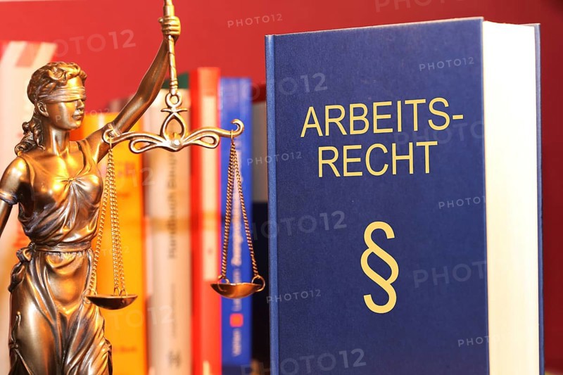 Symbolic image: Labour law reference book and a Justitia