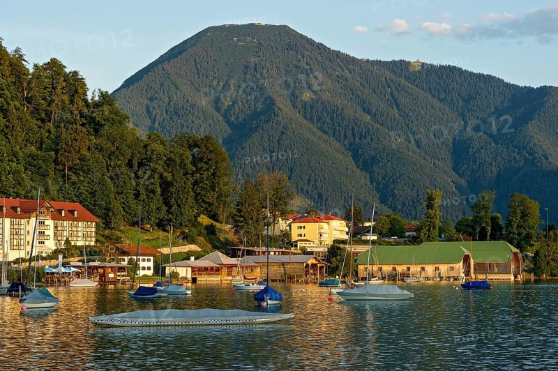 Tegernsee with sailing boats and boat huts, warm evening light, town Tegernsee, mountain Wallberg, Mangfall mountains, Bavarian Prealps, Alps, Upper Bavaria, Bavaria, Germany, Europe