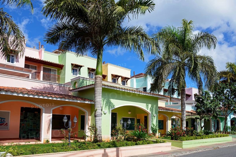 Colourful houses under a blue sky with palm trees create a tropical and relaxed atmosphere, Bayahibe, Dominican Republic, Hispaniola, Caribbean, America, Central America