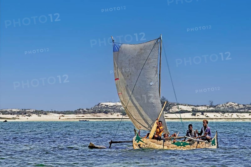 Malagasy fishermen sailing in traditional wooden fishing boat, outrigger canoe on the Indian Ocean, Andavadoaka, Atsimo-Andrefana Region, Madagascar, Africa