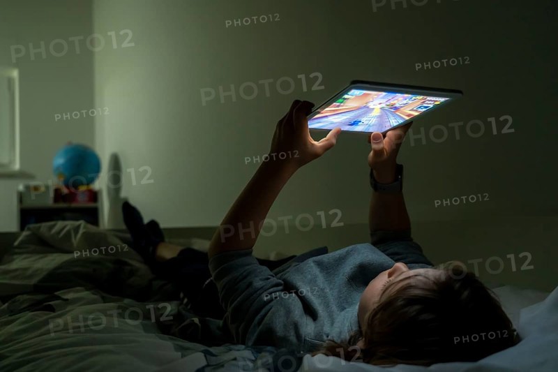 A boy plays computer games on a tablet PC