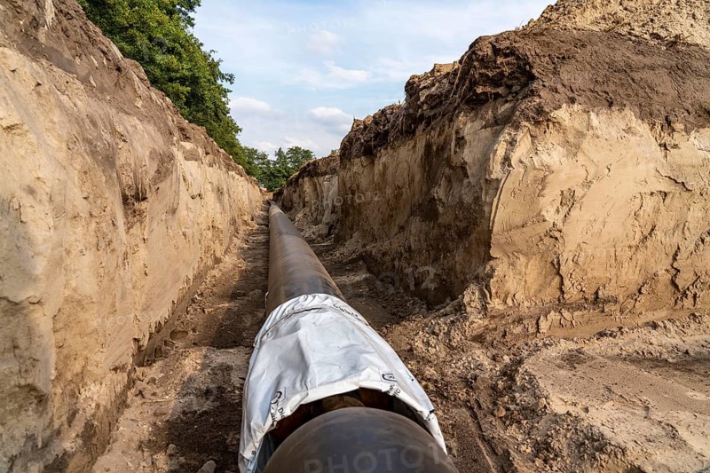 Laying of district heating pipes, next to a field, with maize, the district heating comes from a biogas plant and is fed directly into households in the neighbourhood, private provider, near Delbrück, North Rhine-Westphalia, Germany, Europe