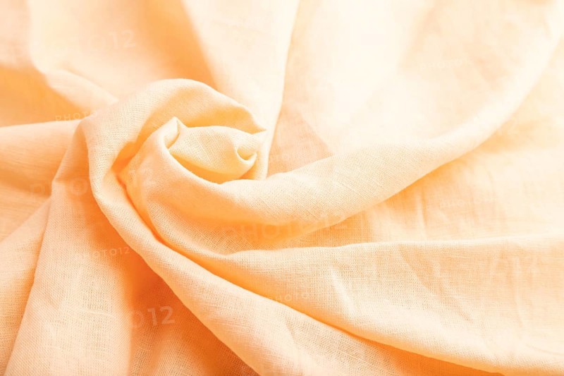 Fragment of orange linen tissue. Side view, natural textile background and texture. wave concept, abstract, spiral form