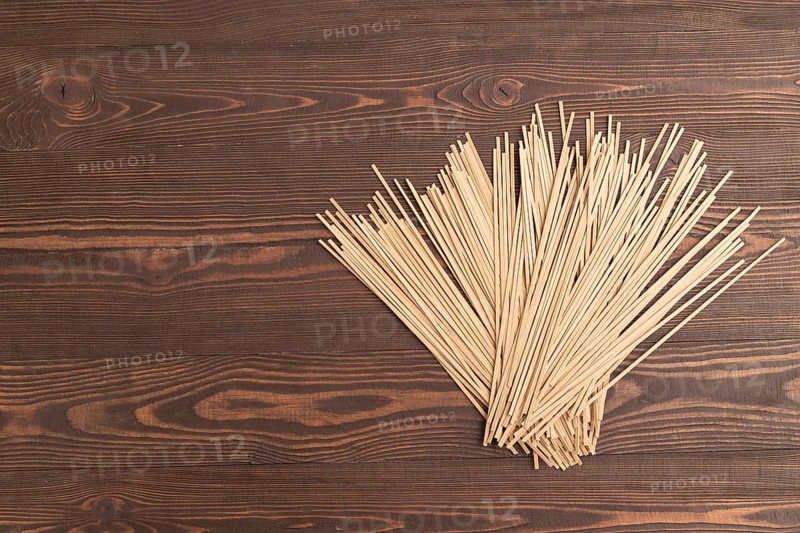 Japanese buckwheat soba noodles on brown wooden background. Top view, flat lay, copy space