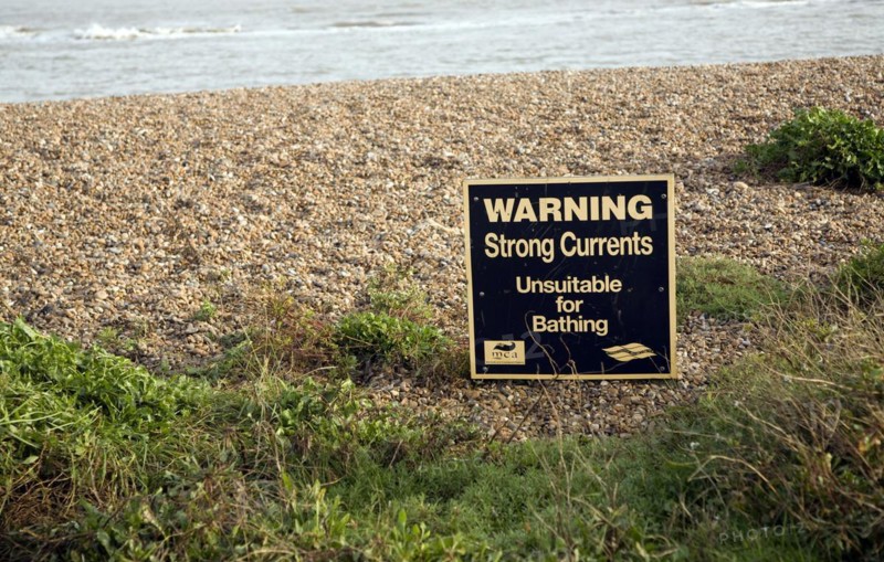 Sign warning of strong currents water unsuitable for bathing, Shingle Street, Suffolk, England, UK