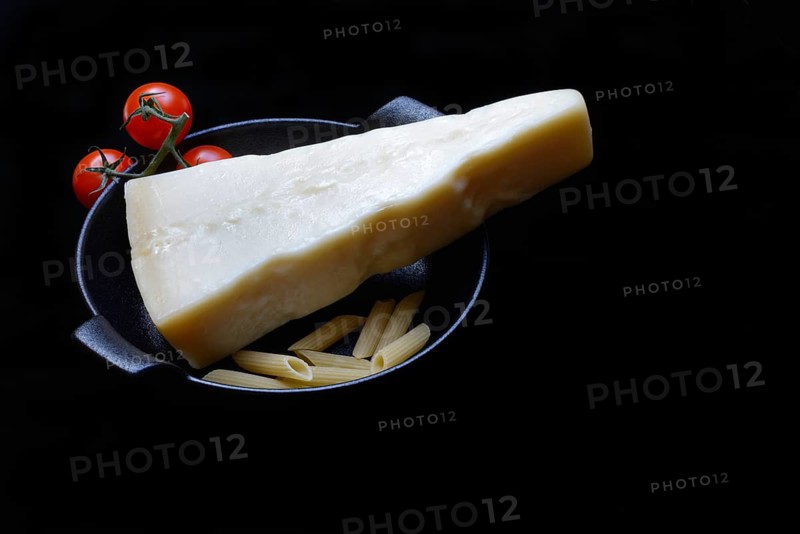A piece of Parmesan cheese with tomatoes and pasta, Italy, Europe