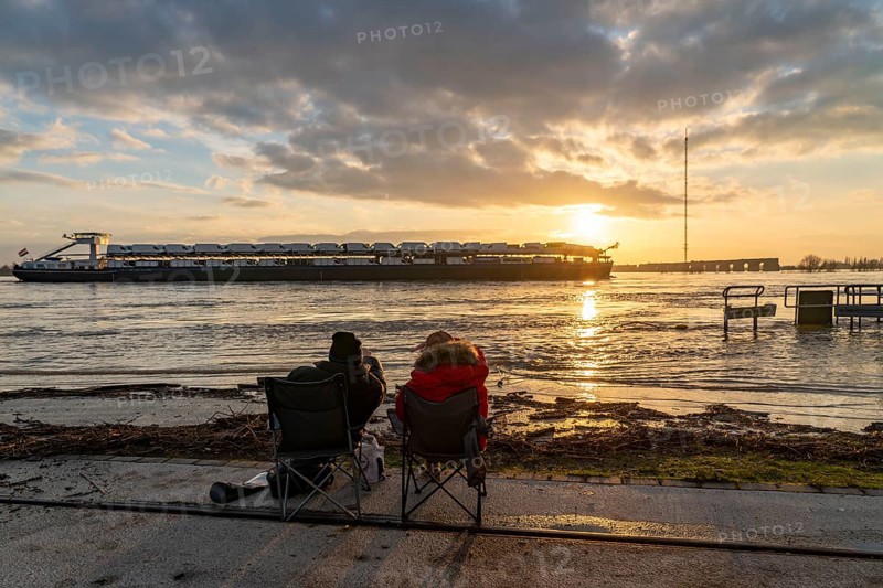 Rhine flood, riverside promenade in Wesel, partly the river water is already spilling onto the paths, 2 men with camping chairs at flood-watching, Wesel, North Rhine-Westphalia, Germany, Europe
