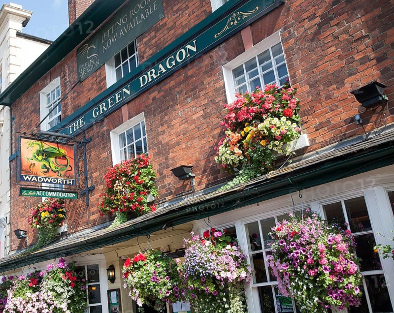 Exterior sign and floral display outside the Red Dragon pub in Marlborough, Wiltshire, England, United Kingdom, Europe