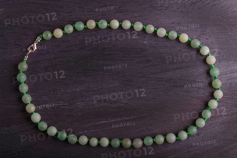 Green agate colored beads on a black background. top view, close up