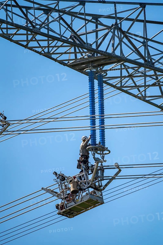 Construction of a new line route, 380 KV extra-high-voltage line between Osterath and Gohr, near Neuss, fitters in line trolleys, on the conductor cables, installing field spacers at great heights, North Rhine-Westphalia, Germany, Europe