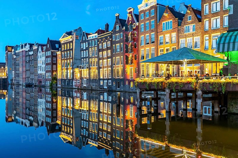 Canal houses on the Damrak, in the centre of the old town of Amsterdam, harbour, starting point of many canal tours, evening, Netherlands