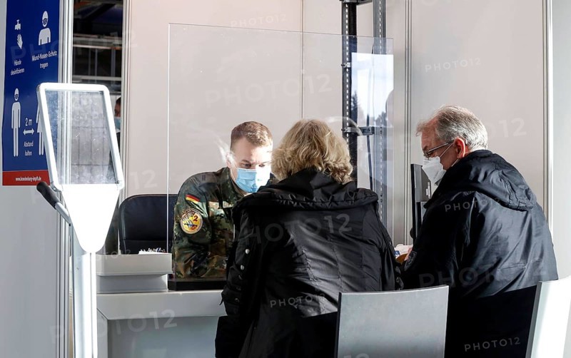 Bundeswehr soldiers help with the registration of vaccinees in front of their booster vaccination against Covid 19 at the Schönefeld vaccination centre, 03.12.2021