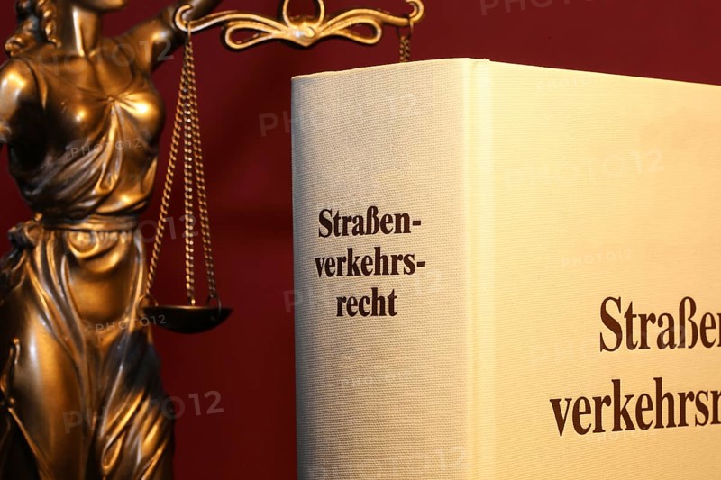 Symbolic image: Textbook on traffic law and a Justitia