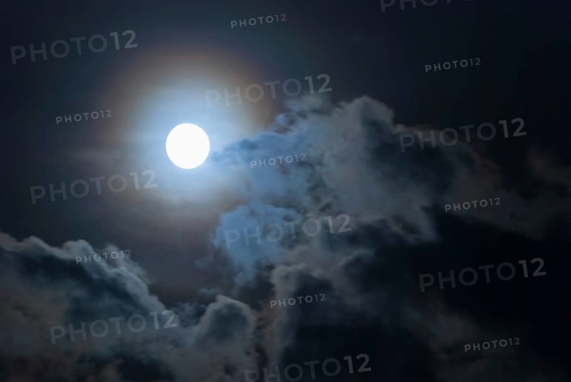 The full moon shines brightly in a cloudy, stormy, black sky and has a halo in rainbow colours (corona, halo), fairytale-like, mystical night shot, dark, somewhat creepy mood, ghostly, symbolic image for fear, nightmare, horror, fantasy, motion blur, wipe effect, Mecklenburg-Western Pomerania, Germany, Europe