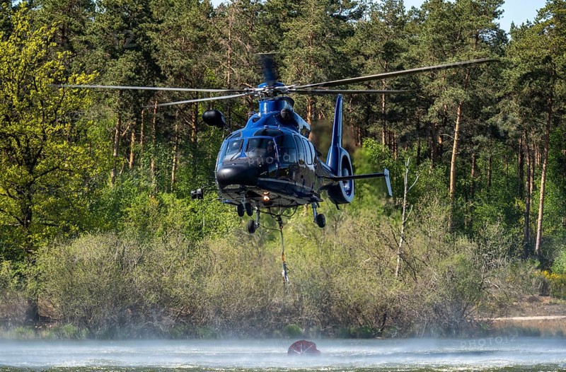 Forest fire in the German-Dutch border region near Niederkrüchten-Elmpt, in a nature reserve, deployment of fire-fighting helicopters, Eurocopter EC 155, Federal Police with extinguishing water tank, Bambi Bucket