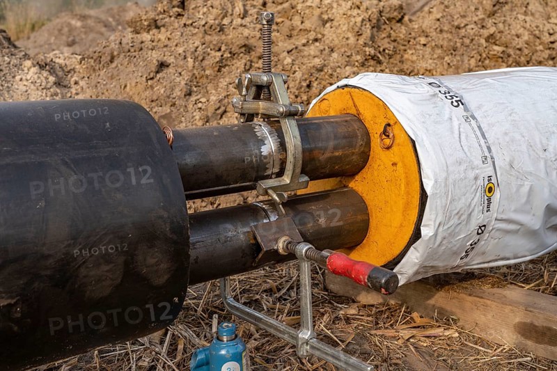 Laying of district heating pipes, next to a field, with maize, the district heating comes from a biogas plant and is fed directly into households in the neighbourhood, private provider, near Delbrück, North Rhine-Westphalia, Germany, Europe