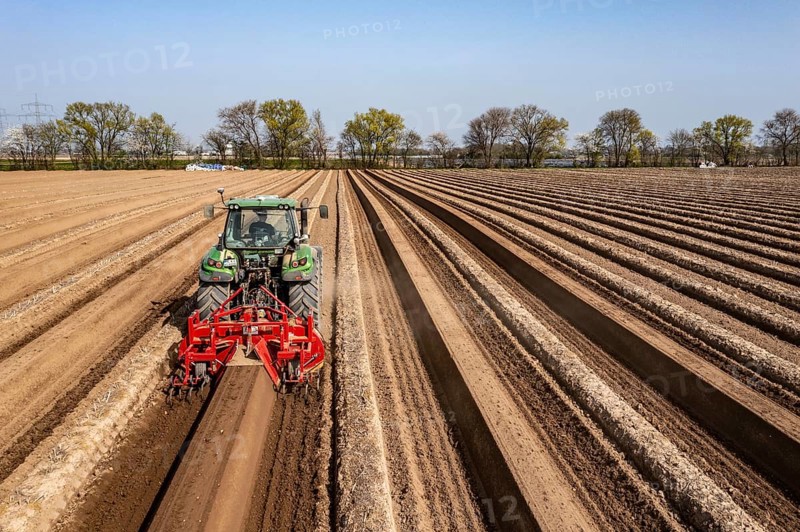 A farmer builds asparagus ridges on a field with the help of an asparagus tiller, in which the asparagus then grows, Dormagen, North Rhine-Westphalia, Germany, Europe