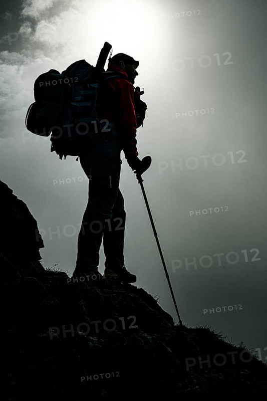 Mountaineer with luggage in the background Rätikon mountains with cloudy sky, Tschagguns, Rätikon, Montafon, Vorarlberg, Austria, Europe