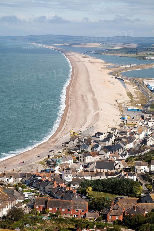 Chesil beach tombolo with housing in Chiswell in the foreground, Isle of Portland, Dorset, England, UK