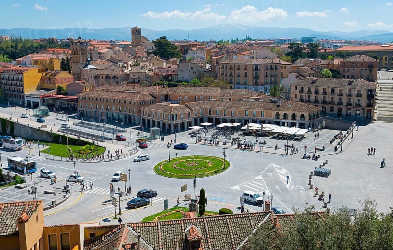 Lively town square with surrounding historic buildings and a green circular flower bed, Segovia, Castilla y León, Leon, Spain, Europe