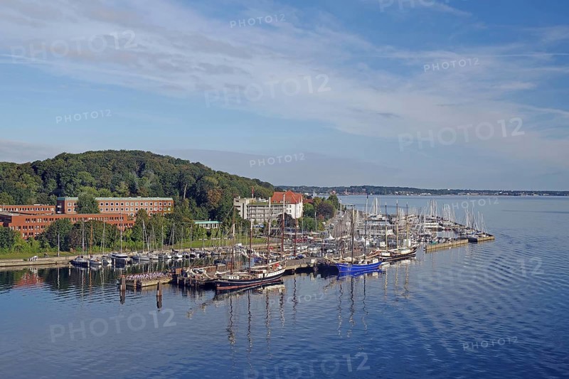 A harbour full of sailing ships, surrounded by buildings and green hills under a blue sky, Kiel-Holtenau, Kiel Fjord, Kiel, Schleswig-Holstein, Germany, Europe
