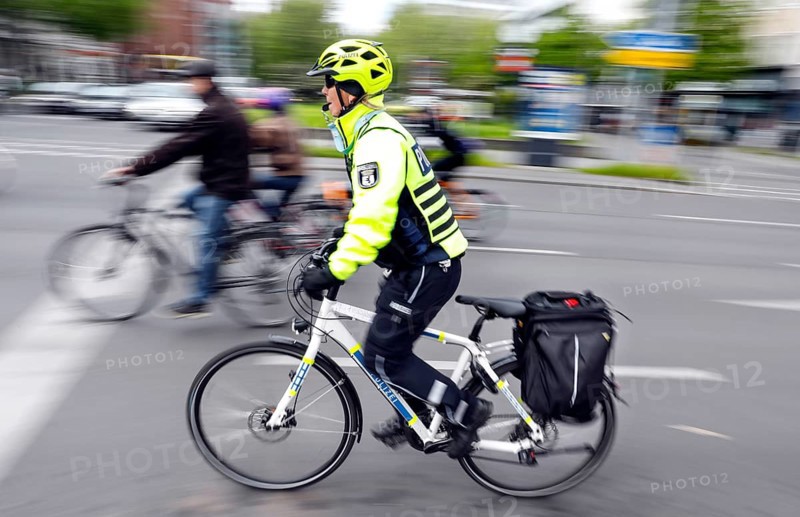 A policewoman from the Berlin bicycle squadron accompanies the bike parade demonstration, Berlin, 07 05 2023