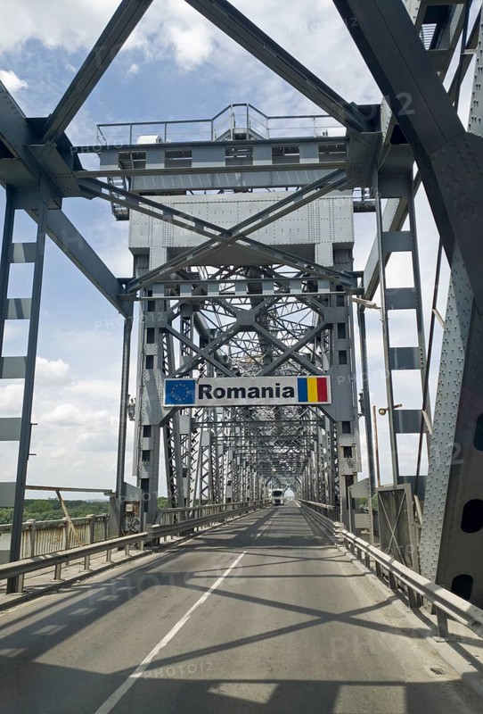 A steel bridge with a sign for Romania under a partly cloudy sky, Giurgiu-Russe Friendship Bridge, Bridge of Friendship, steel truss bridge, bridge over the Danube between the cities of Russe in Bulgaria and Giurgiu in Romania, south portal, Bulgaria, Europe