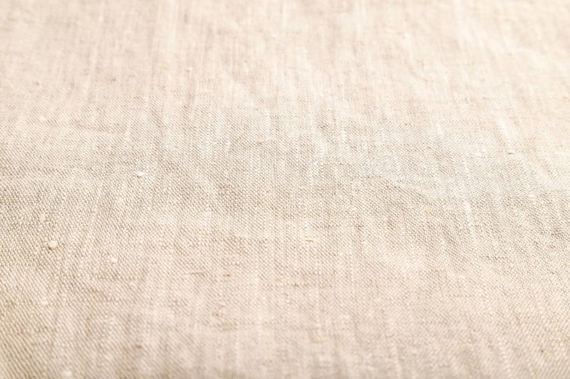 Fragment of smooth white linen tissue. Side view, natural textile background and texture