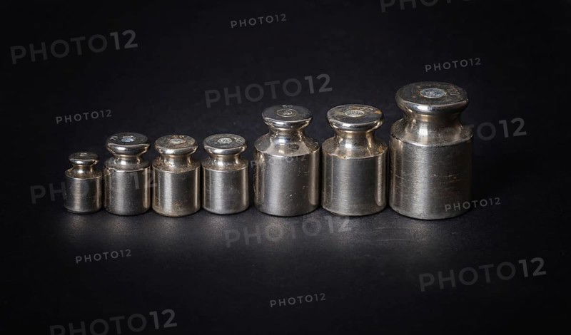 A set of small metal weights on a gray background