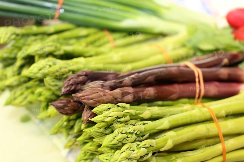 Green and purple asparagus, radishes in the background