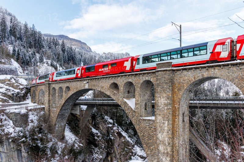Glacier Express train of the Rhaetian Railway at the Solis viaduct of the Albula railway in the Alps in Solis, Switzerland, Europe