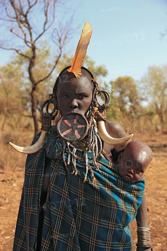 South Ethiopia, in Maco National Park, Mursi tribe, Mursi woman with baby, painted skin and headdress, plate lip woman, woman with plate in lower lip, lip jewellery, Ethiopia, Africa