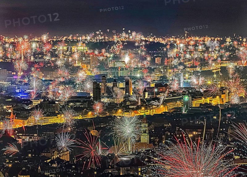 Stuttgart welcomes the New Year 2024 with fireworks over the city centre. In the centre of the picture: town hall tower, collegiate church and Old Palace, in the foreground the tower of St. Mark's Church, Stuttgart, Baden-Württemberg, Germany, Europe