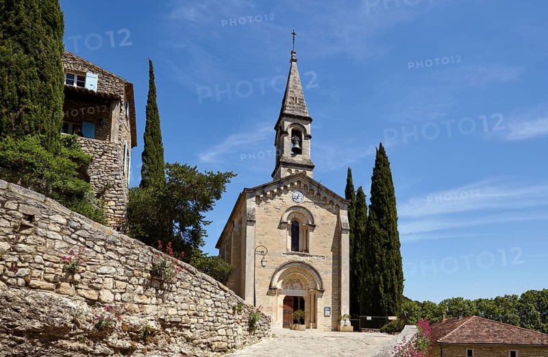 La Chapelle l'Eglise with mediterranean cypresses (Cupressus sempervirens) in La Roque-sur-Cèze, Gard department, Occitanie region, France, Europe