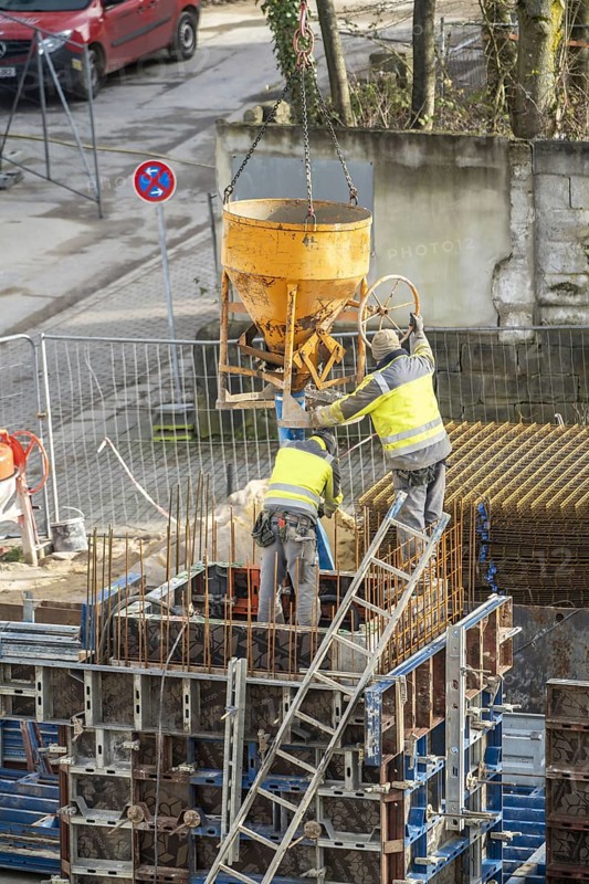 Construction site, concreting, the lift shaft of a building is concreted, the concrete is placed on the reinforced concrete mats using a concrete bomb