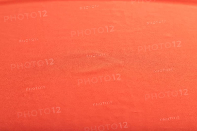 Fragment of smooth red silk tissue. Top view, flat lay, natural textile background and texture