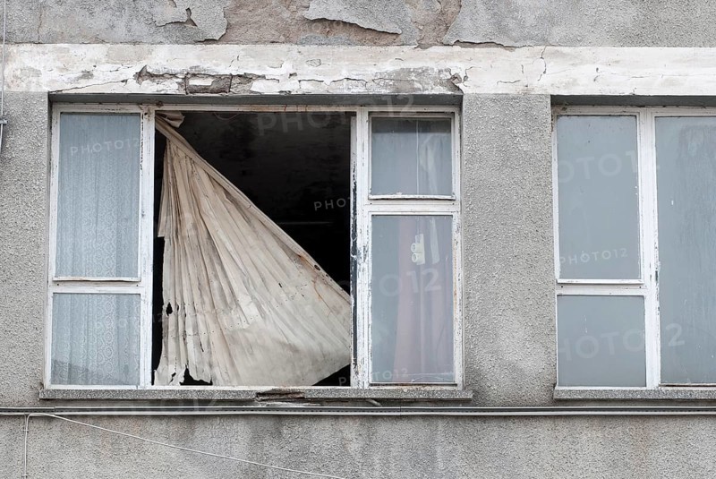 A damaged window with a torn blind in a decaying building, facade, crumbling paint, crumbling plaster, empty house, decay, vacancy, Mecklenburg-Western Pomerania, Germany, Europe