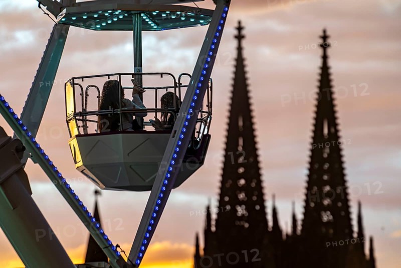 Happy Colonia funfair, Corona-compliant funfair at the Deutzer Werft, on the Rhine, Cologne Cathedral, Abendrot, Ferris wheel, a temporary amusement park of the Cologne Showmen's Association, under Corona conditions, with entrance fee and admission only with the 3-G conditions, distances, one-way street, Cologne, North Rhine-Westphalia, Germany, Europe
