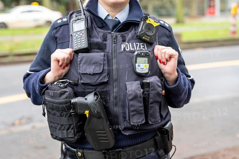Police, policewoman with equipment waistcoat, CO measuring device device, above a bodycam, first aid pack, taser, digital radio, torch, handcuffs, North Rhine-Westphalia, Germany, Europe