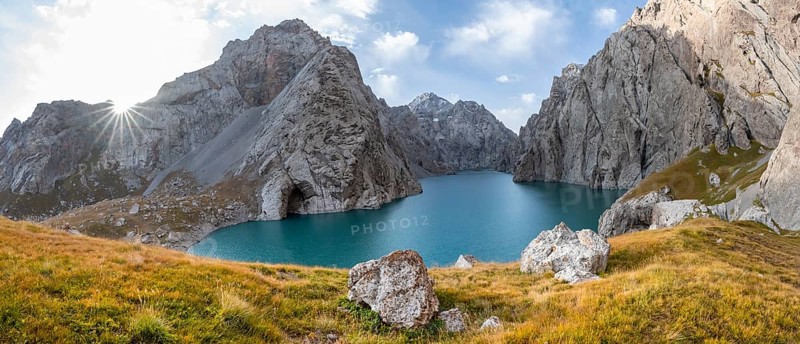 Mountain lake Kol Suu with rocky steep mountains, Sun Star, Kol Suu Lake, Sary Beles Mountains, Naryn Province, Kyrgyzstan, Asia