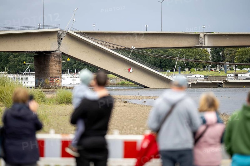 Passers-by look at the partially collapsed Carola Bridge from the Königsufer in Dresden, 11/09/2024
