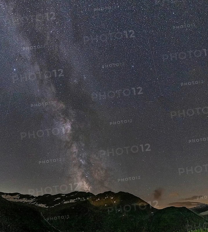 Nocturnal starry sky over the Furka Pass in the Swiss Alps. The night photograph shows the stars of the Milky Way and shooting stars. Obergoms, Valais, Switzerland, Europe