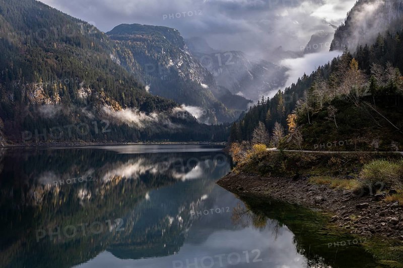 The Vordere Gosausee in autumn. In the background, the Dachstein mountain range in clouds. Cloudy sky. A few rays of sunshine. Vorderer Gosausee, Gosau, Gosau Valley, Salzkammergut, Upper Austria, Austria, Europe