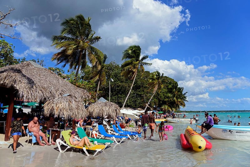 Holidaymakers spending time on the beach with inflatable toys in the water, Boca Chica, Santo Domingo Province, Dominican Republic, Hispaniola, Caribbean, America, Central America
