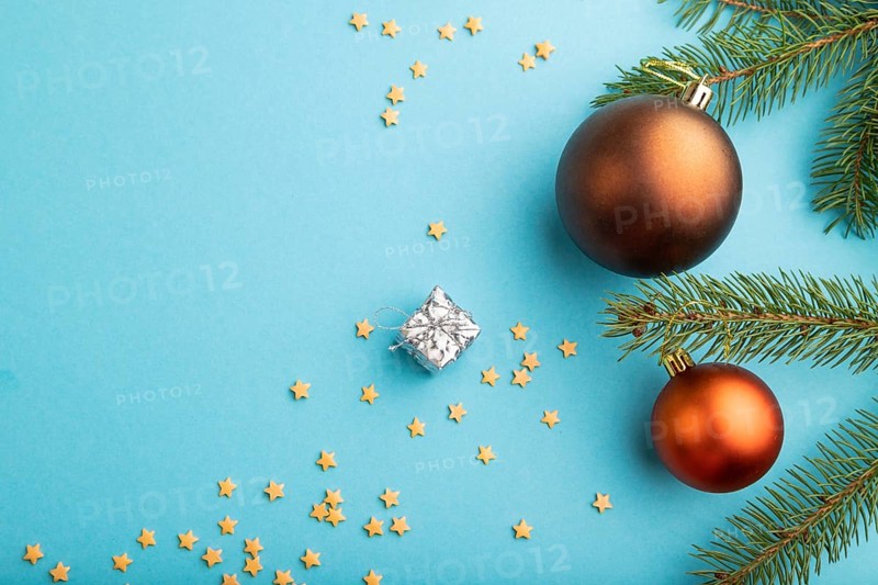 Christmas or New Year composition. Decorations, bronze balls, fir and spruce branches, on a blue paper background. Top view, copy space, flat lay