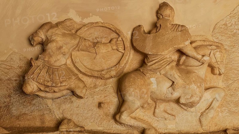 Stone relief of a horseman in battle, battle of the Greeks against the Amazons, richly detailed carving in sandstone, Archaeological Museum, Archea Korinthos, Corinth, Peloponnese, Greece, Europe
