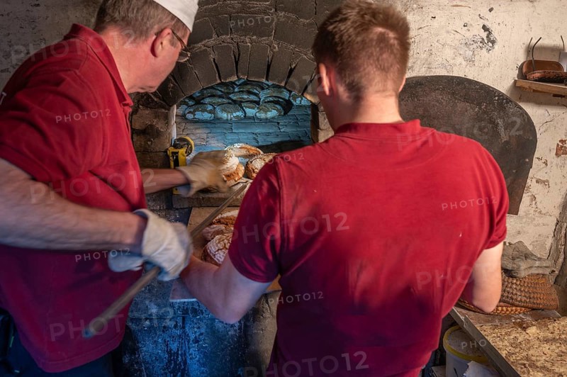 Freshly baked wood-fired bread is taken out of the wood-fired oven, Franconia, Bavaria, Germany, Europe
