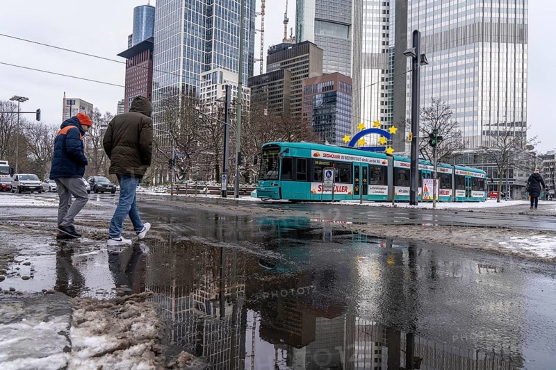 Winter in the city, Gallusanlage street, puddles, pools of water, melt water, pedestrians, Frankfurt, Hesse, Germany, Europe