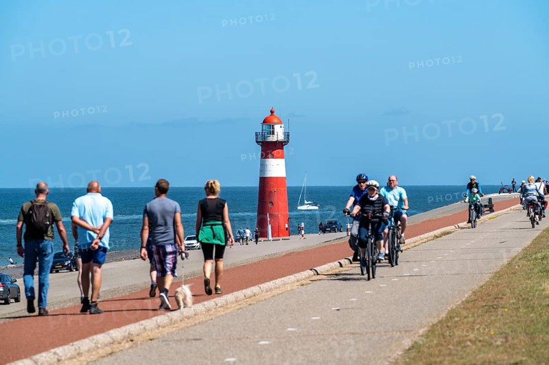 North Sea dyke near Westkapelle, Westkapelle Laag lighthouse, cyclists on the Zeeuwse Wind Route cycle path, province of Zeeland, Walcheren peninsula, Netherlands
