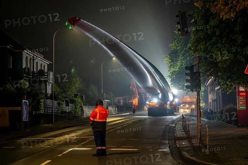 Transport of a 68 metre long, 22 tonne blade of a wind turbine, here in Breckerfeld, with a self-propelled Blade-Lifter vehicle, over a 40 km long route, over 2 nights, in the Bergisches Land, through towns, villages, over country roads, narrow through roads, to the construction site of the wind turbine near Hagen, North Rhine-Westphalia, Germany, Europe